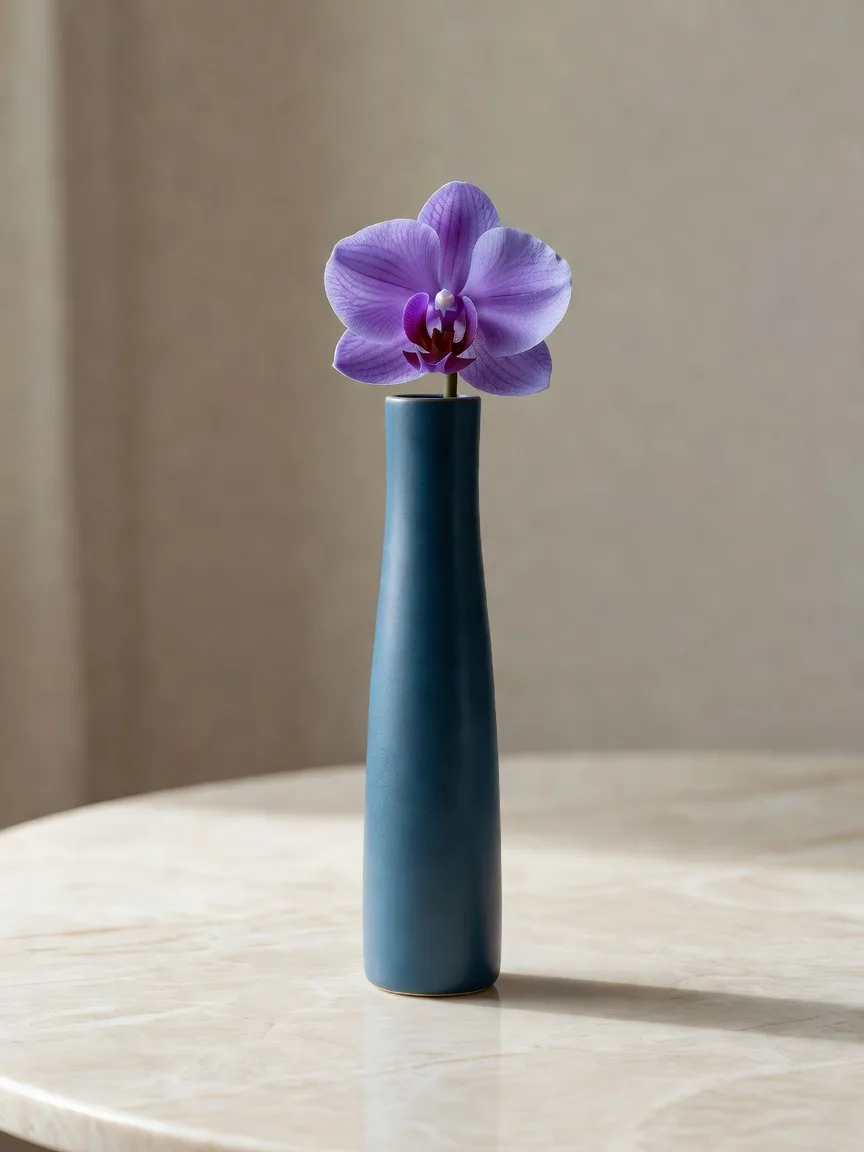 藍色の細い花瓶に生けた紫の蘭の花